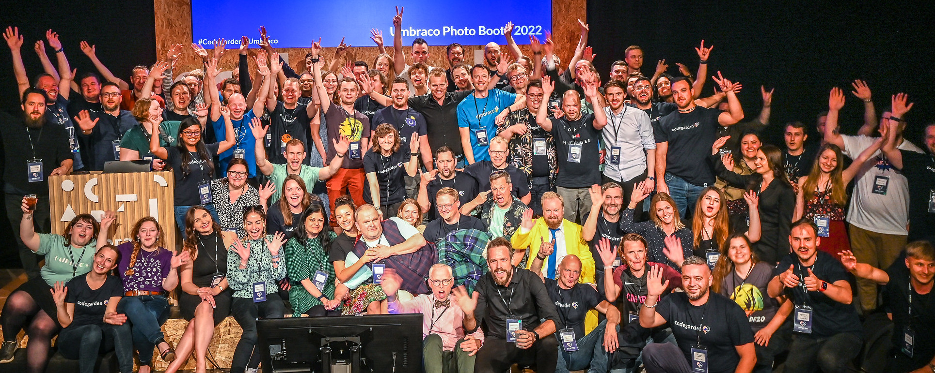 A photo by Umbraco HQ on Flickr of a group photo of HQ employees from Codegarden 2022. They have their hands raised in the air and are smiling and cheering.